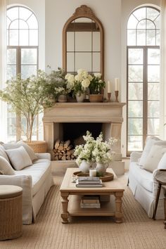 a living room filled with furniture and a fire place in front of two large windows