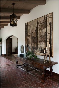 a large painting hanging on the wall above a wooden table