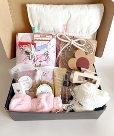 an open box filled with personal care items on top of a white table next to a pillow