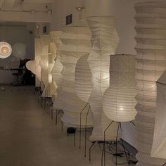 a room filled with lots of white paper lanterns