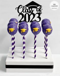 purple and yellow cake pops with graduation cap on top