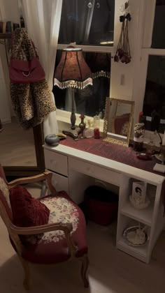 a desk with a chair, lamp and mirror in front of a window filled with stuffed animals