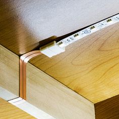 a close up of a drawer with some tape on the bottom and an electrical cord attached to it