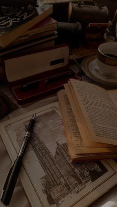 an open book sitting on top of a table next to a cup and saucer