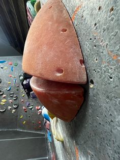 a close up of a rock climbing wall with an object sticking out of it's side