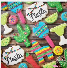 decorated cookies are arranged on a wooden table with the words fiesta spelled in black letters