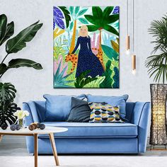 a living room with blue couches and paintings on the wall above it, along with potted plants