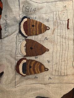 three crocheted mice are sitting on top of a piece of cloth with numbers