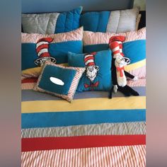 a cat in the hat themed bedding set with pillows and stuffed animals on it