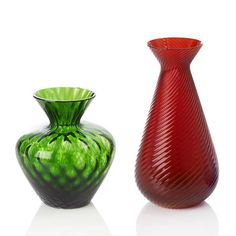 two colorful vases sitting next to each other on a white surface, one red and one green