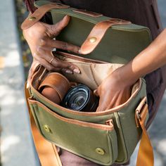 a woman holding a camera in her purse