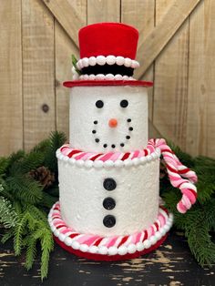 a snowman made out of candy canes sitting on top of a wooden table