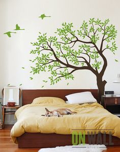 a bedroom with a tree and birds on the wall