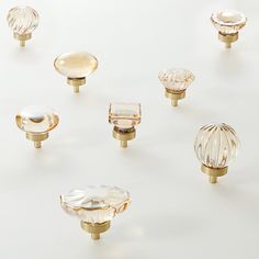 an assortment of glass knobs and pulls on a white surface, including one in the middle