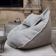 a large bean bag sitting on top of a rug next to a chair and table