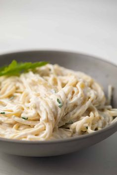 a bowl filled with pasta and garnished with parsley