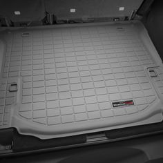 the trunk area of a car with its cargo compartment open and it's floor mat removed