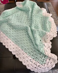 a crocheted blanket sitting on top of a leather chair