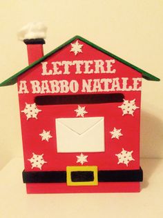 a small red house with snowflakes on the roof and letters written in spanish