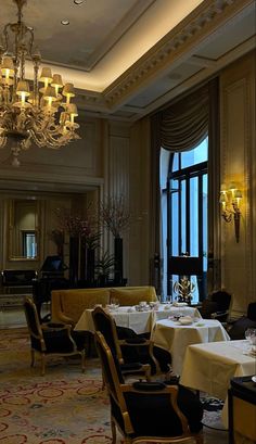 an elegant dining room with chandelier and tables