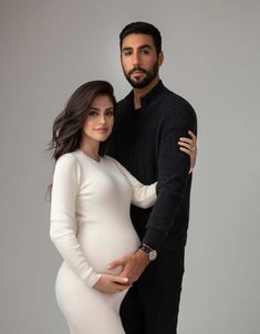 a pregnant woman and man pose for the camera