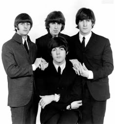 the beatles posing for a black and white photo