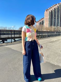 a woman standing in the middle of an empty parking lot with her hand on her hip