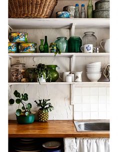 the shelves are filled with dishes and pots