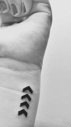 a black and white photo of a person's arm with three arrows on it