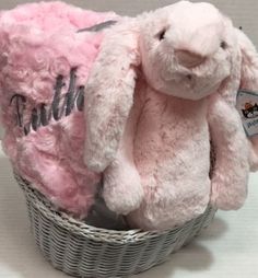 a pink stuffed rabbit sitting in a basket