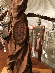 a paper mache sculpture with skeletons hanging from it's sides on a wooden table