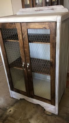 an old cabinet with chicken wire on the doors