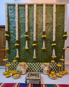 a table topped with plates and bowls filled with food next to a wall covered in flowers