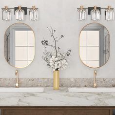 two sinks and mirrors in a bathroom with marble counter tops, gold accents and brass fixtures