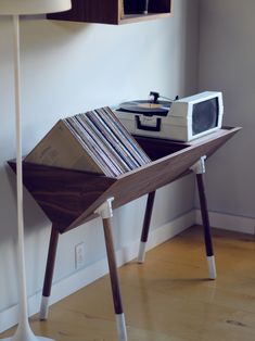 an old record player is sitting on a wooden table next to a wall mounted stereo