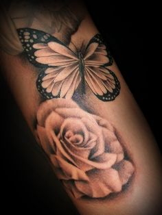 a rose and butterfly tattoo on the arm