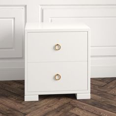 a white nightstand with two gold handles on the bottom and one drawer open, against a wood floor