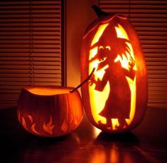 a carved pumpkin with an image of a witch on it next to a lit candle