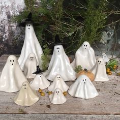 a group of white ghost figurines sitting on top of a wooden table