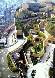 an aerial view of a city with many trees on the roof and buildings in the background