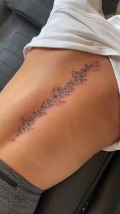 a woman's lower back tattoo with flowers on it