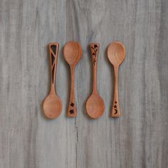 three wooden spoons are lined up next to each other