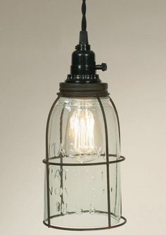 a light hanging from the ceiling with a glass cage on it's side and one bulb