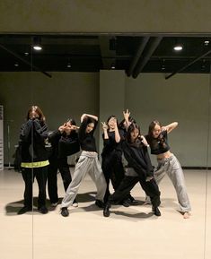 group of people standing in front of a mirror posing for the camera with their hands up