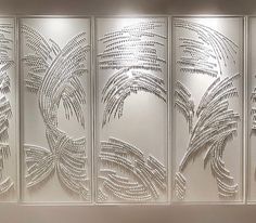 three panels with decorative designs on them in a living room or dining room, each panel has an intricate palm tree and leaves design