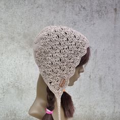 a crocheted hat with long hair on top of a mannequin head