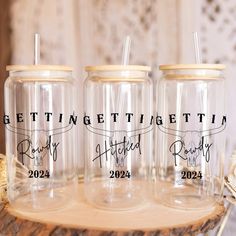 three personalized mason jars sitting on top of a wooden table with straws in them