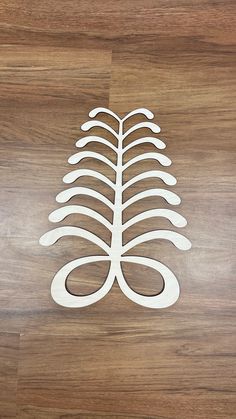 a wooden cutout of a tree on top of a wood floor with the shape of a leaf