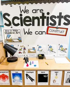 there are posters and pictures on the table in front of this desk that says, we are scientist's we can construct