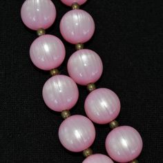 "This vintage necklace is lovely! Single stranded, it features pink moonglow plastic beads (possibly lucite), small metal bead spacers, and has a spring ring clasp. Beautiful! Measures 24.25\" from end to end. Condition : Good.. There's light wear on the beads." Pink Round Beaded Necklaces With Spacer Beads, Pink Necklaces With Spacer Beads, Vintage Pink Beaded Necklaces For Jewelry Making, Vintage Pink Beaded Necklace As A Gift, Pink Single Strand Necklace With Round Beads, Adjustable Single Strand Pink Beaded Necklace, Pink Vintage Beaded Necklaces With Colorful Beads, Pink Necklaces With 8mm Beads, Vintage Pink Beaded Necklace With Round Beads